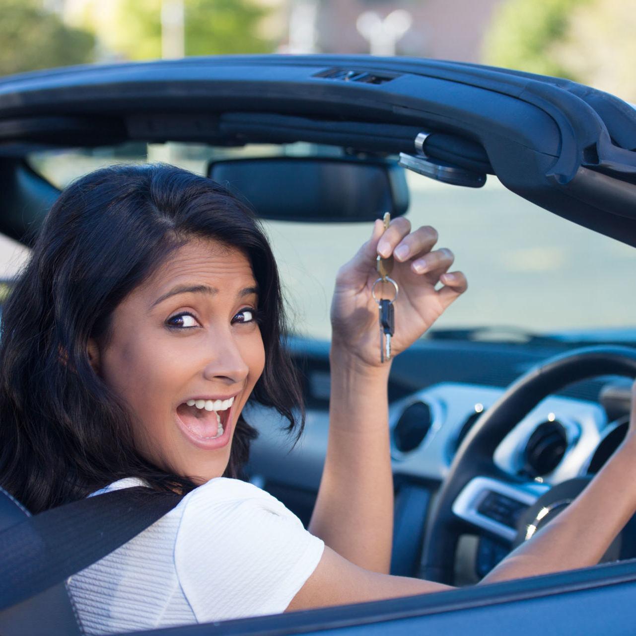 一名妇女在获得汽车贷款的预先批准后，拿着新车的钥匙微笑着